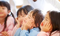 子どもたちが笑顔で頬杖をしてる